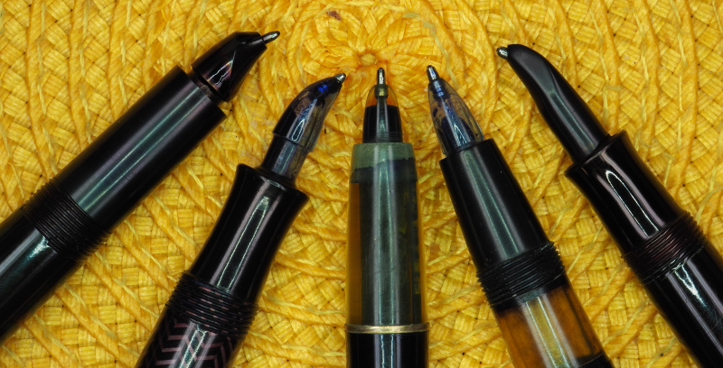 Schreibspitzen von fünf verschiedenen Tintenkugelschreibern aus den 50er Jahren (von links nach rechts): Riepe GmbH Rollkuli, Sphinx Rubidor, Montblanc-Simplo 444, Roulette Diamant 55, UHU Kugeltinter